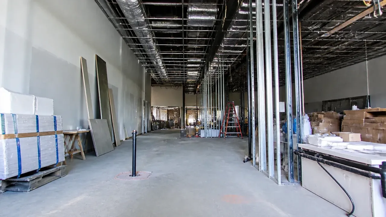A build-out scene illustrating what the build-out phase owes BOH, shot low and wide to show the height of the room